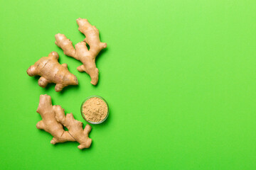 Fototapeta na wymiar Finely dry Ginger powder in bowl with green leaves isolated on colored background. top view flat lay