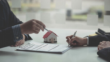 Real estate agent or sales manager has proposed terms and conditions to customers who sign house purchase agreements with insurance, Agreement to sign the purchase contract concept.