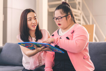 young girl with autism is practicing fun playing with toys at home with his mother. Autistic young students are learning with teachers happily.