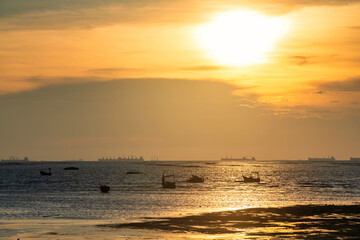 Fototapeta na wymiar Silhouette fishing boats and cargo ships at sunset, Sriracha