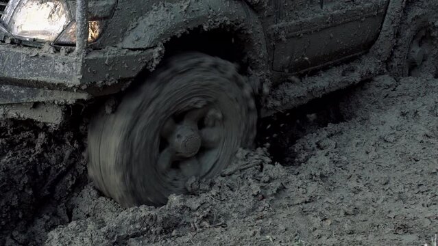 Off road car wheels on damaged road. Tire on bad road. Outdoor, adventures, expedition, and travel suv. Close-up car tyre tracks. Close-up shot of wheel in dirt slow motion.