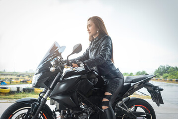 Plakat biker woman in black leather jacket sit on motorbike.