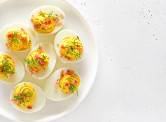 Stuffed eggs with egg yolk, bacon, mustard on plate