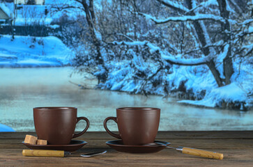Two cups of tea on background of a winter landscape, outdoors