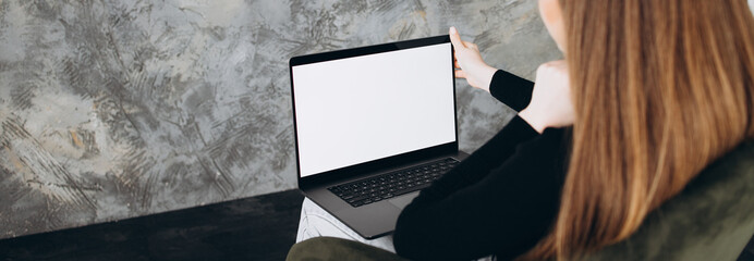 Mockup image of a woman using and typing on laptop with blank white desktop screen