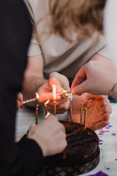 Birthday cake : group of friends preparing chocolate cake with candles. Vertical image