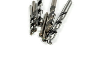 several different metal drills on a white background. close-up