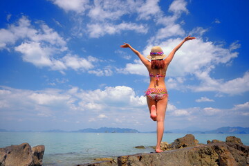 Free action and relaxing of bikini tanned Thai girl on white sand beach at Krabi, Thailand. Concept image for summer vacation in tropical country, Thailand.