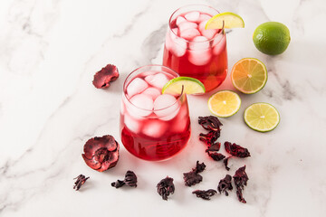 two glass glasses with hibiscus rose tea and with lots of ice, slices of lime. chilled thirsty...