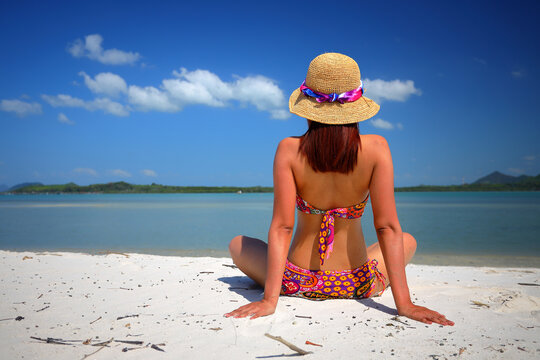 Free action and relaxing of bikini tanned Thai girl on white sand beach at Krabi, Thailand. Concept image for summer vacation in tropical country, Thailand.