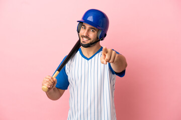 Baseball player with helmet and bat isolated on pink background pointing front with happy expression