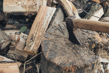 The ax lies on the wood. Firewood chopping. Preparation of firewood for the winter. Iron ax with...
