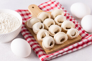 Russian Pelmeni on Cutting Board and Ingredients for Homemade Ravioli or Dumplings with Meat Horizontal