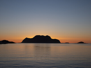 Naklejka na ściany i meble Stunning sunset along the breathtaking fjords, skerries and islands of the Norwegian Western Coast near Ålesund, Møre og Romsdal, Norway.