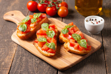 Italian tomato and cheese bruschetta. Tapas, antipasti with chopped vegetables, herbs and oil on grilled ciabatta and baguette bread.