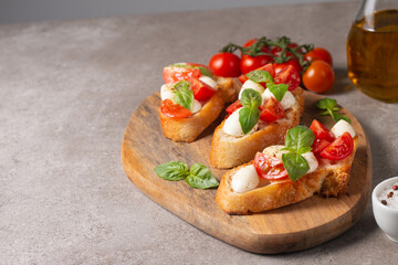 Italian tomato and cheese bruschetta. Tapas, antipasti with chopped vegetables, herbs and oil on grilled ciabatta and baguette bread.