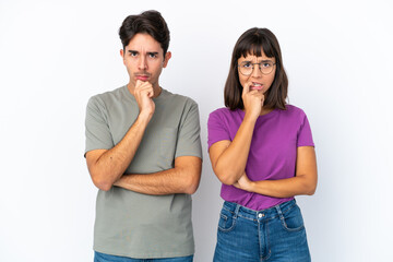 Young couple isolated on isolated white background having doubts while looking up