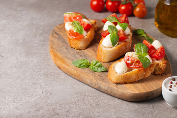 Italian tomato and cheese bruschetta. Tapas, antipasti with chopped vegetables, herbs and oil on grilled ciabatta and baguette bread.