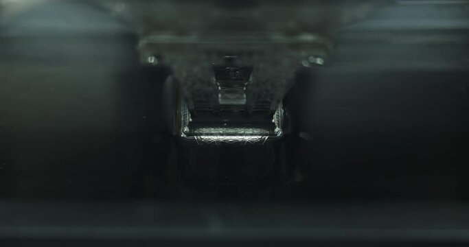 Front view Close up shot of resin Resin MSLA 3D Printer printing anobject in clear resin with UV light