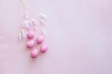 pink easter eggs on pink background with flower and place for text. Minimal