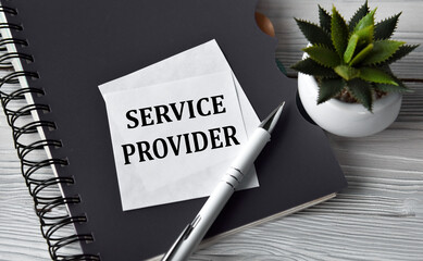 SERVICE PROVIDER - words in a white notebook against the background of a black notebook with a pen