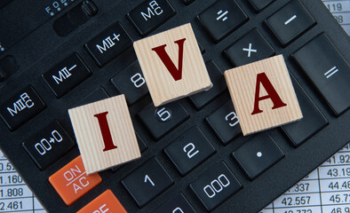 IVA - acronym on wooden cubes on the background of a calculator