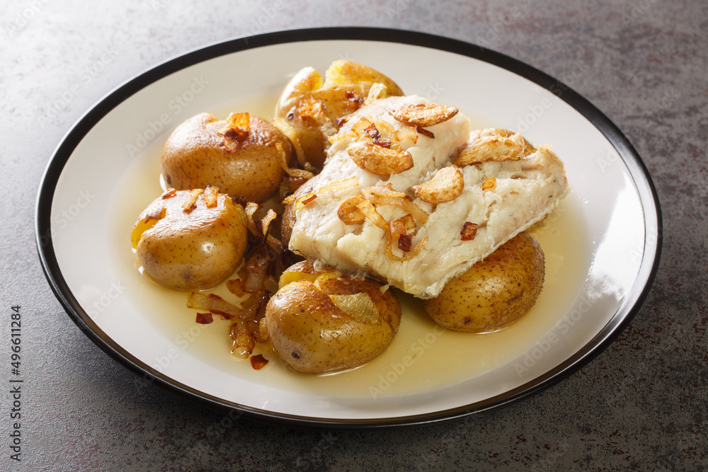 Poster Traditional Bacalhau a Lagareiro Grilled Salted Cod with Olive Oil served with baked Potatoes closeup in the plate on the table. Horizontal