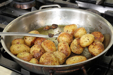 New potatoes cooking in a pan in a restaurant kitchen
