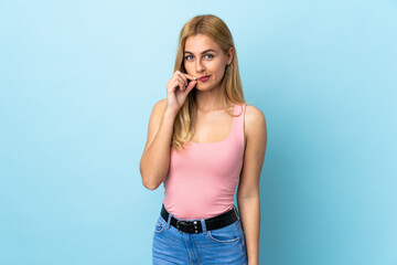 Young Uruguayan blonde woman over isolated blue background showing a sign of silence gesture