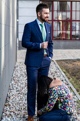 A woman stylist prepares a male model for a photo shoot
