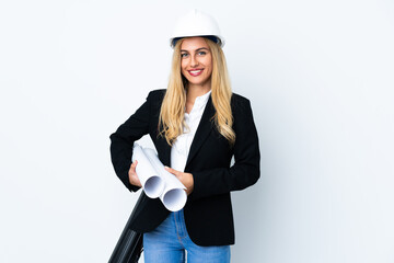 Young architect woman with helmet and holding blueprints over isolated white background applauding