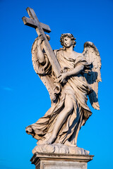Angel with the Cross statue by Ercole Ferrata on Ponte Sant'Angelo Saint Angel Bridge over Tiber river in historic center of Rome in Italy