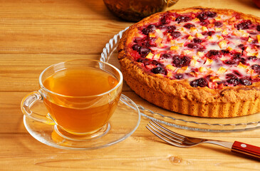 Closeup homemade cherry and apple pie and cup of tea on wooden table.