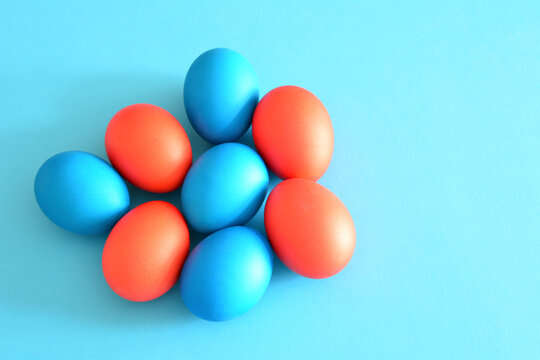 easter eggs painted in blue and red on blue background, close-up © Irina