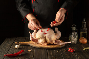 The cook adds red viburnum to the broiler chicken before roasting. Cooking national dishes in the kitchen of the restaurant