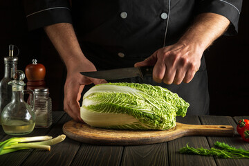 Professional chef cuts Peking cabbage with a knife. Cooking vegetable salad in kitchen. Vegetarian cuisine