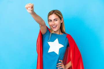 Blonde woman over isolated background in superhero costume with proud gesture - obrazy, fototapety, plakaty