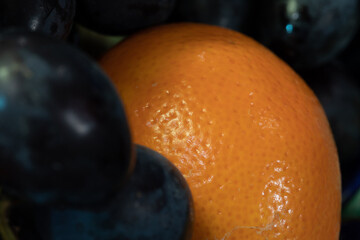 Ripe orange and juicy grapes. Orange citrus fruit and dark grapes. Fruit plate. Vitamin healthy food.