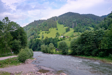 Summer landscape with river and green mountains.