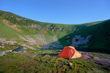 Tourism and traveling concept. Beautiful summer landscape with mountains and tourist tent.