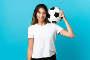 Young caucasian woman isolated on blue background with soccer ball