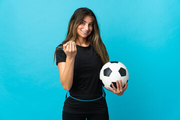 Young football player woman isolated on blue background inviting to come with hand. Happy that you came