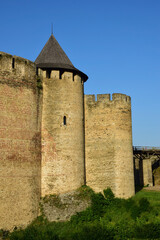 Part of the old stone wall of a medieval fortress with battlements and battlements