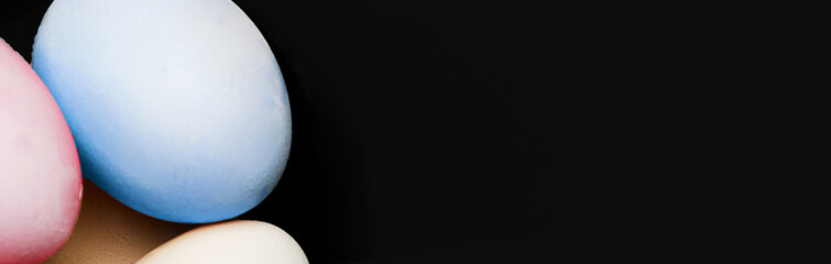 Easter eggs banner on black background. Natural home product. Fresh eggs with hard shadows on a...