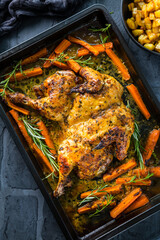 Butterflied grilled whole chicken on a black baking pan
