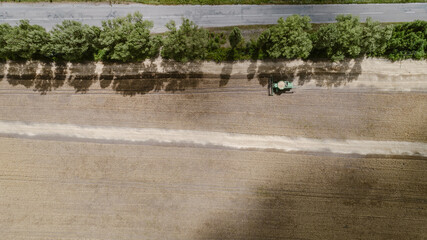 Obraz na płótnie Canvas Aerial view combine harvester harvesting on the field