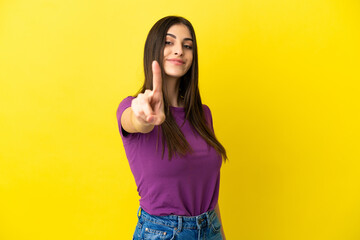 Young caucasian woman isolated on yellow background showing and lifting a finger