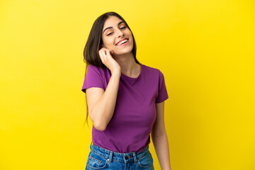 Young caucasian woman isolated on yellow background laughing