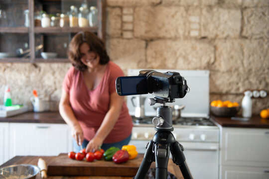 european woman creating content in her home kitchen for her social media channel