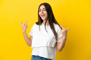 Young caucasian woman isolated on yellow background giving a thumbs up gesture